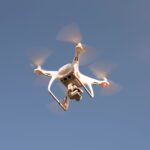 A drone equipped with LiDAR technology flying over a landscape for aerial surveillance and data collection.